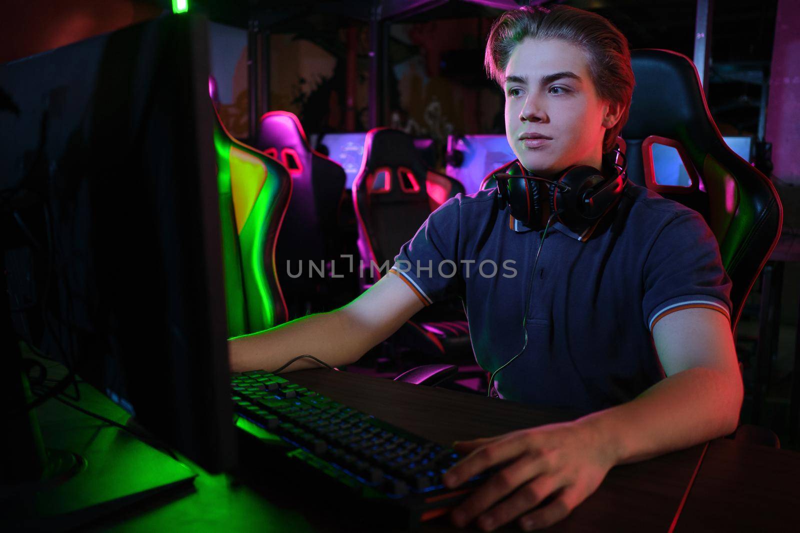 Professional photo of young male caucasian cyber sportsman in gaming club training for important match.