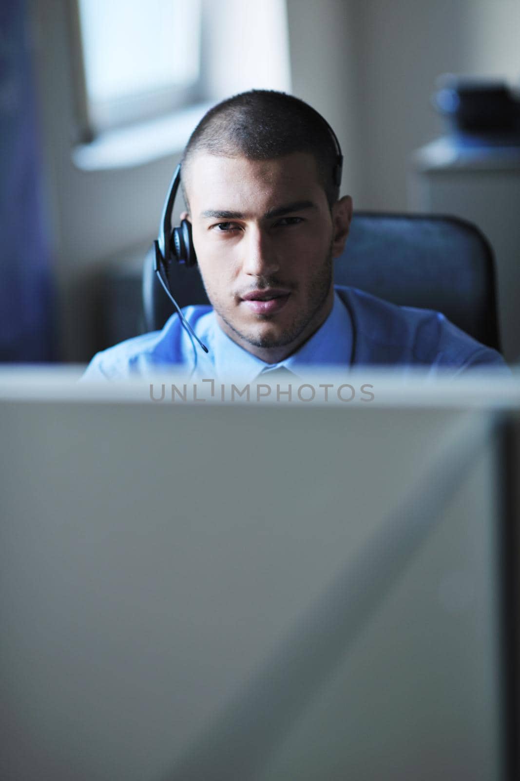 businessman with a headset portrait at bright call center helpdesk support office