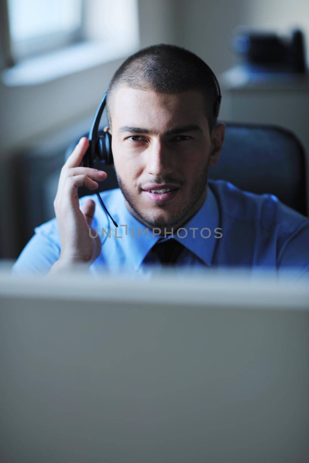 businessman with a headset portrait at bright call center helpdesk support office