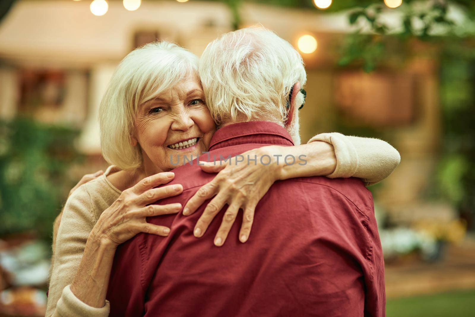 Elderly couple enjoying the evening while dancing by friendsstock