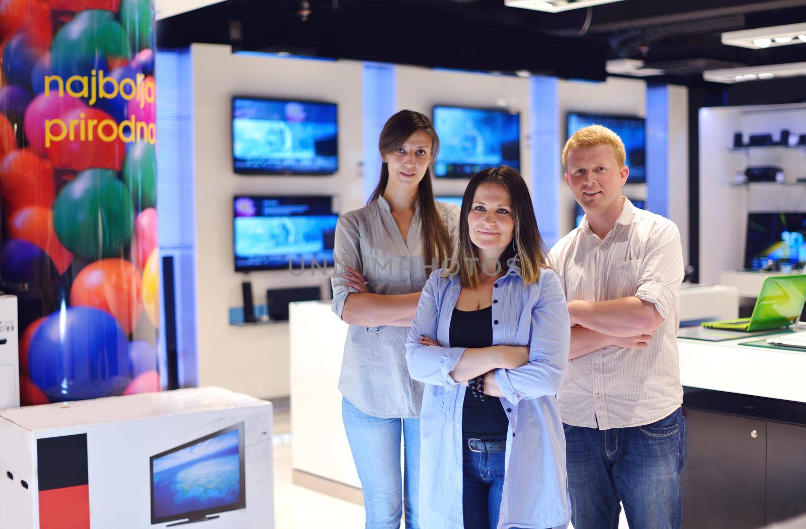 people in consumer electronics  retail store looking at latest laptop, television and photo camera to buy