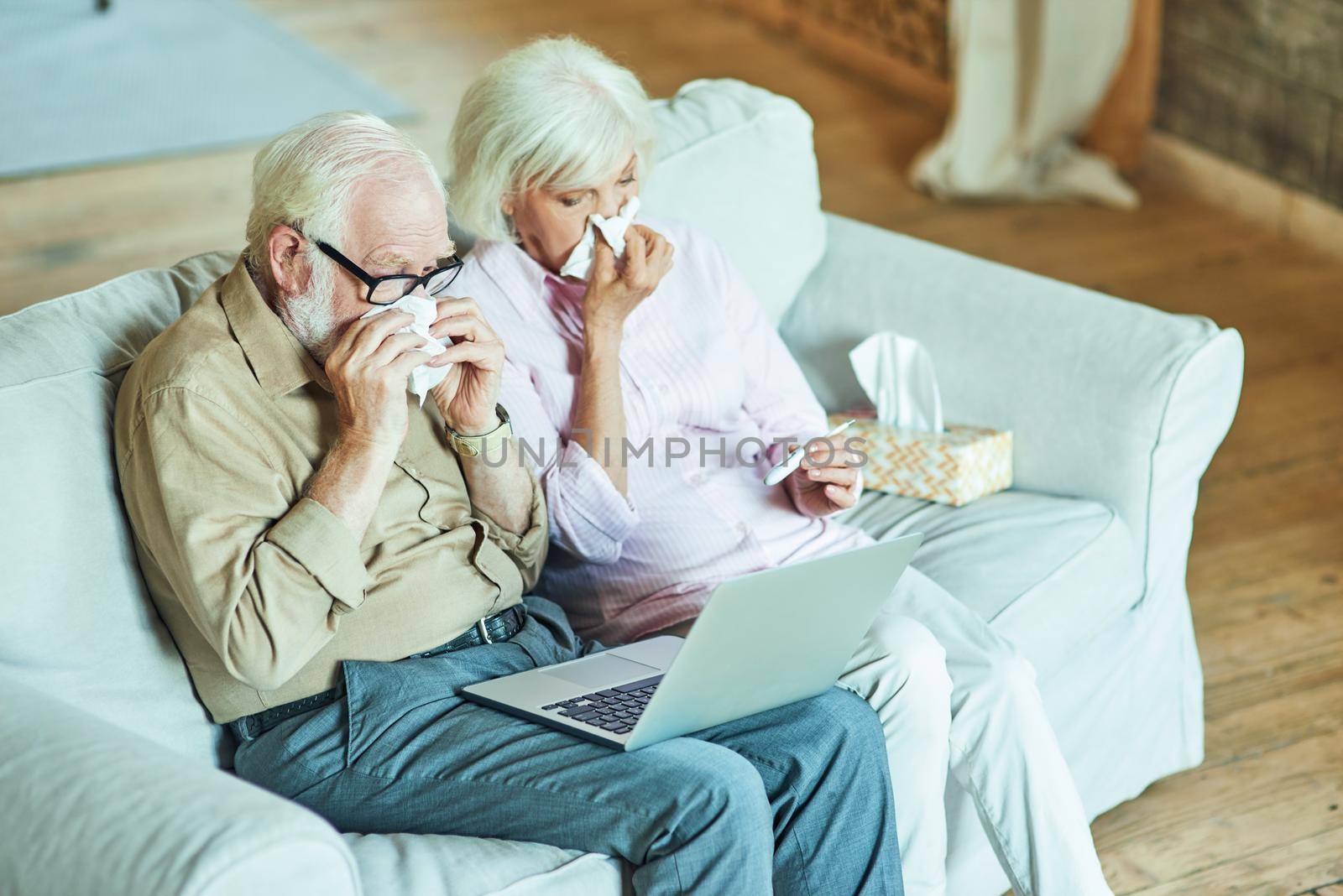 Gray-haired man and woman feeling sick at home by friendsstock