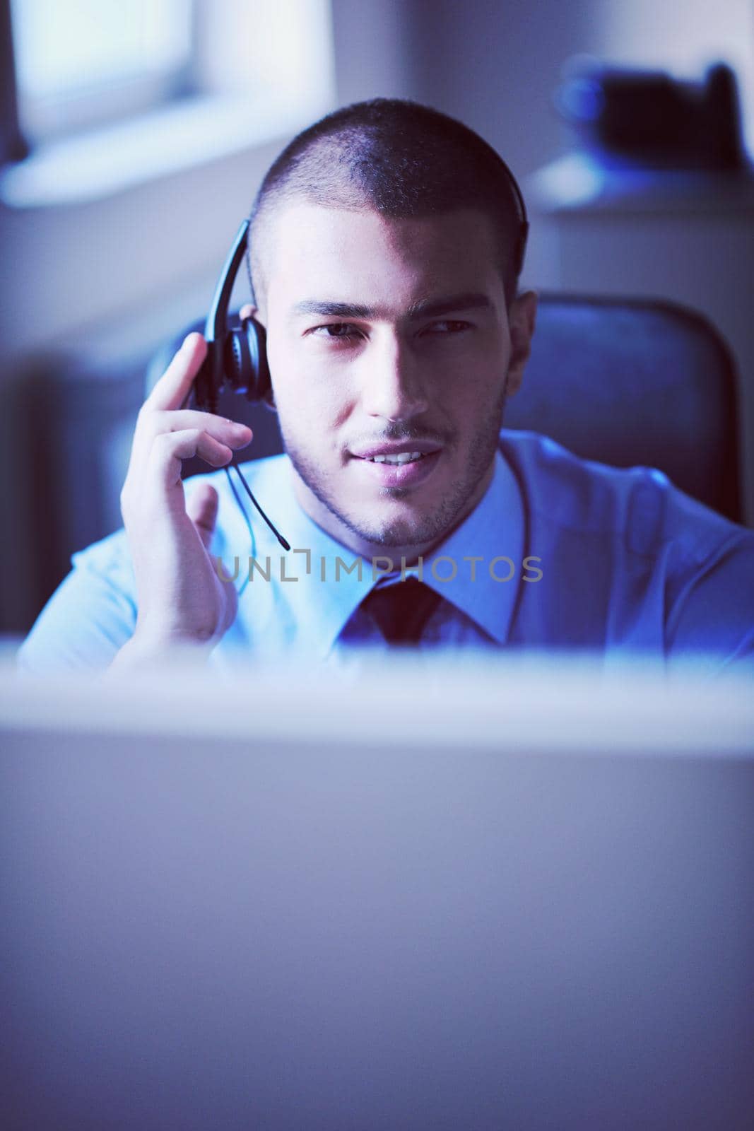 businessman with a headset portrait at bright call center helpdesk support office