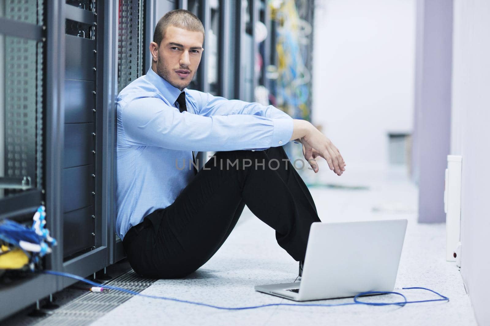 businessman with laptop in network server room by dotshock