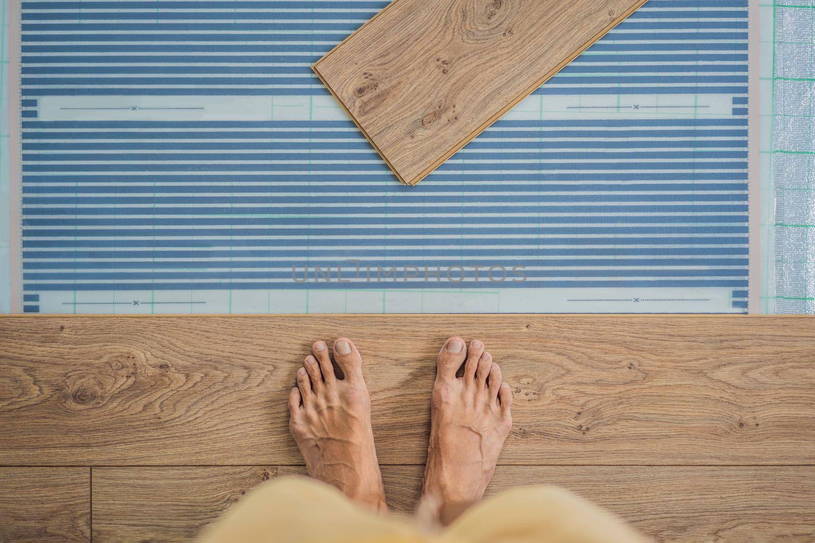 Wooden floor, laminate on a warm film floor. Comfort in home. Warm floor concept. Heating in the house and apartment by galitskaya