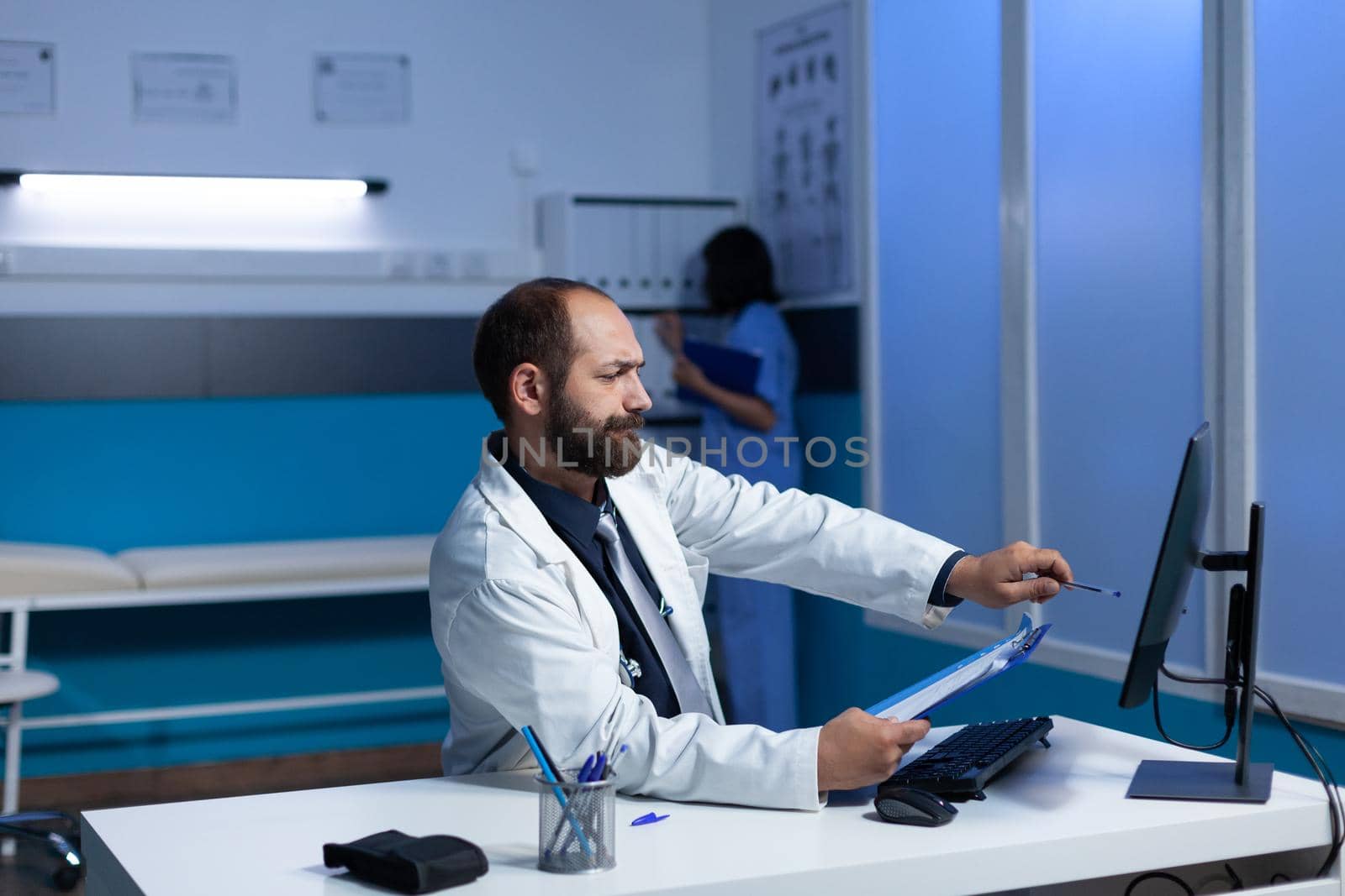 Concentated physician pointing at monitor for examination by DCStudio