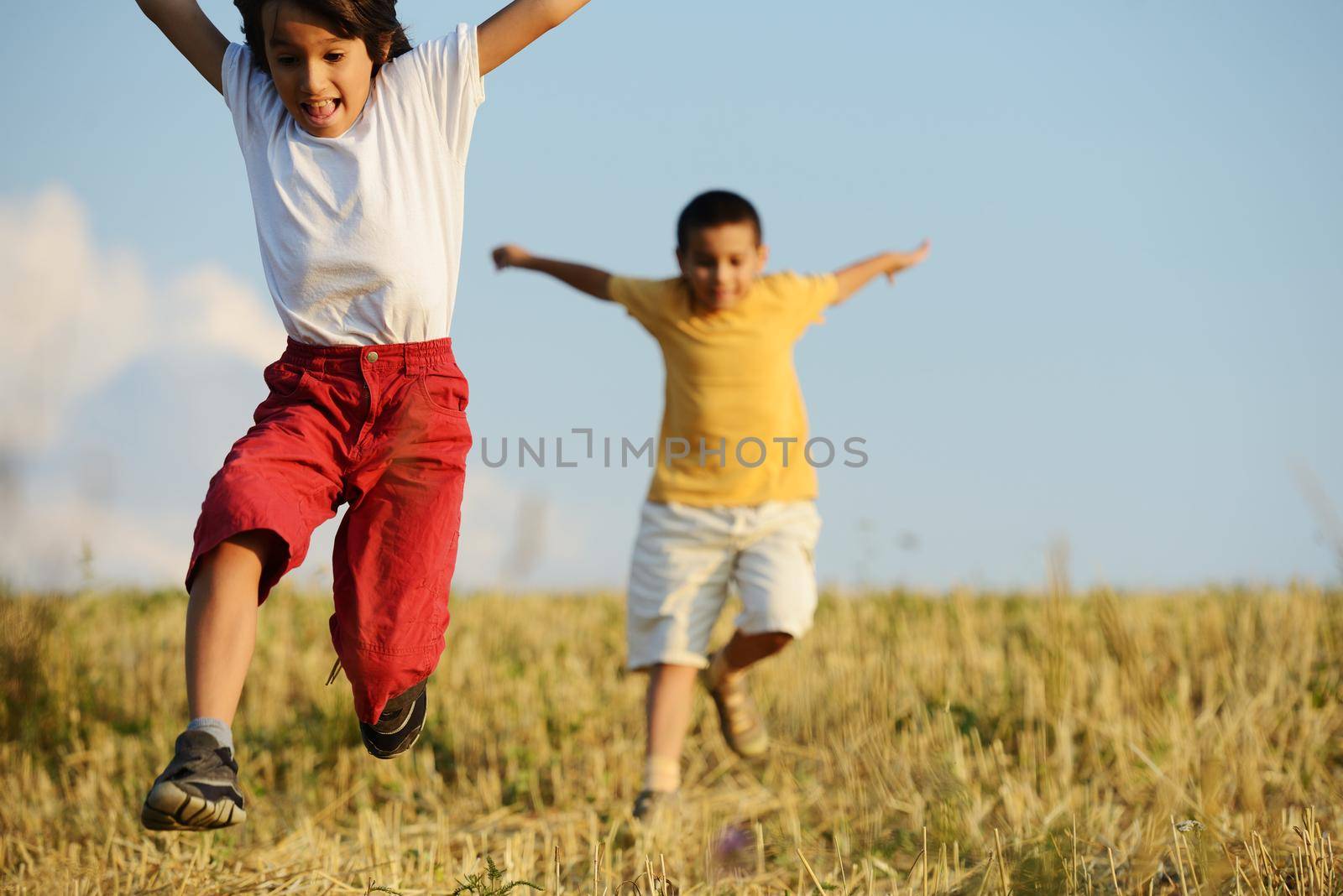 Happy children running on beautiful field