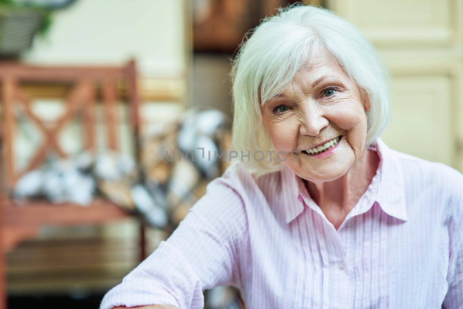 Waist up photo of happy pretty senior woman resting outdoors with her van on the background. Lifestyle concept