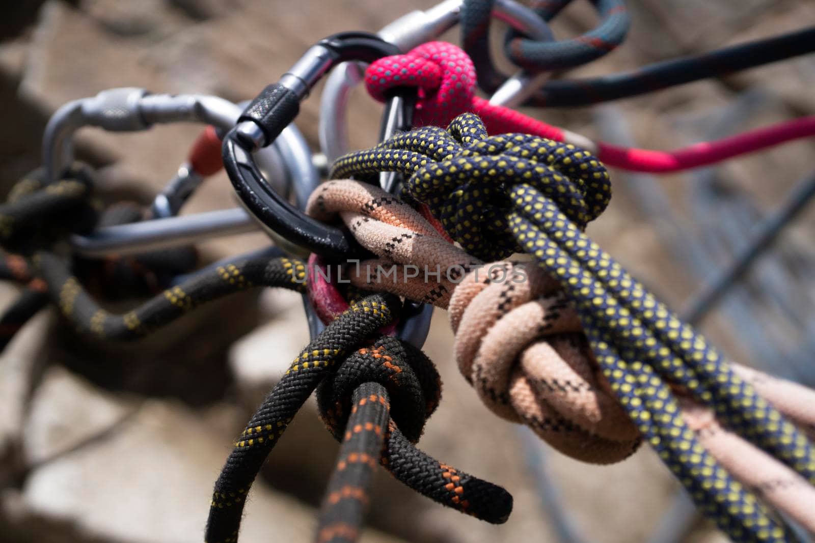 Climbing accessories, tools, carabiners and ropes at the belay station in the mountains during the climb to the summit.