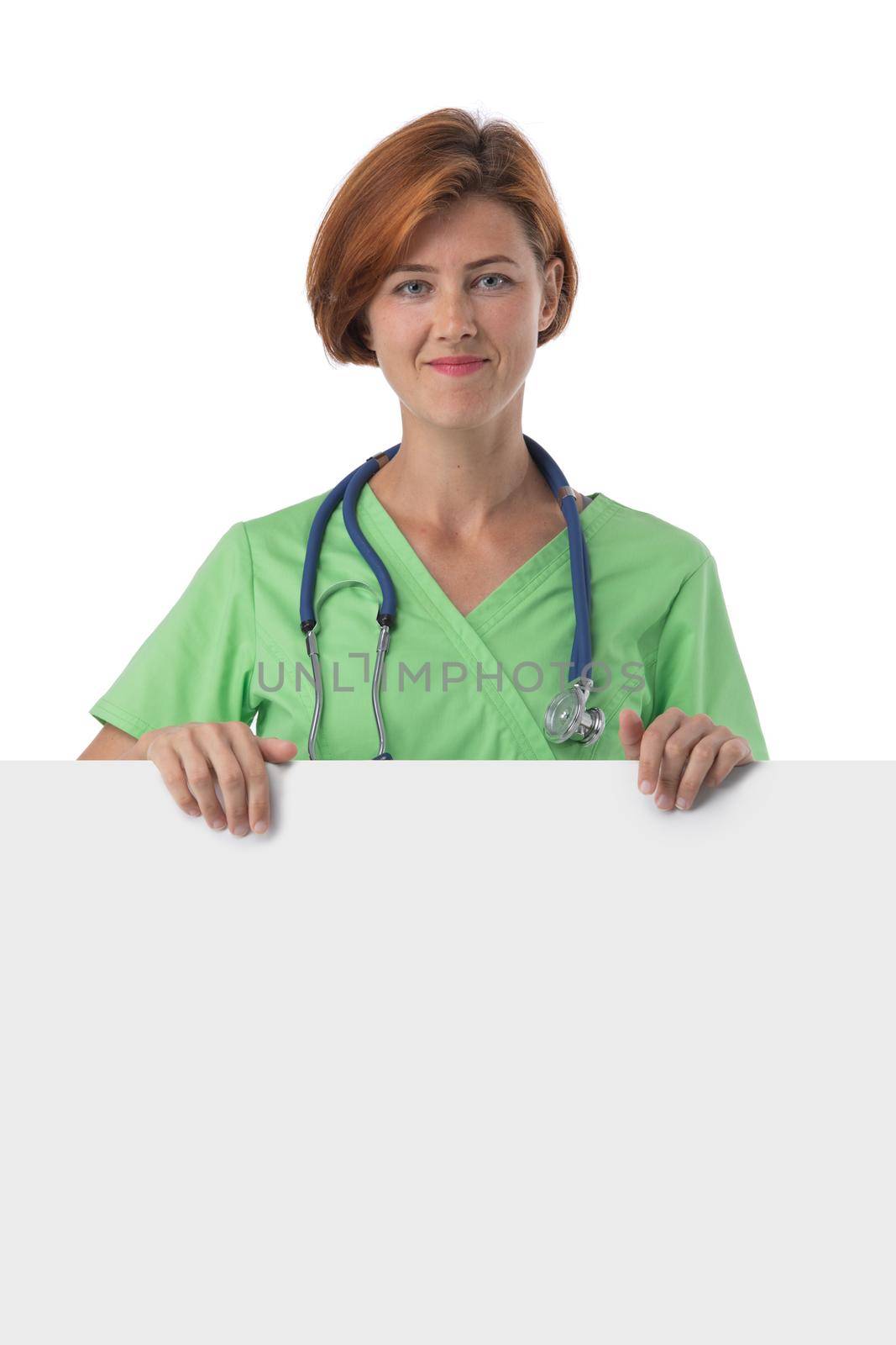Portrait of a beautiful caucasian readhead female doctor nurse with blank banner isolated on white background