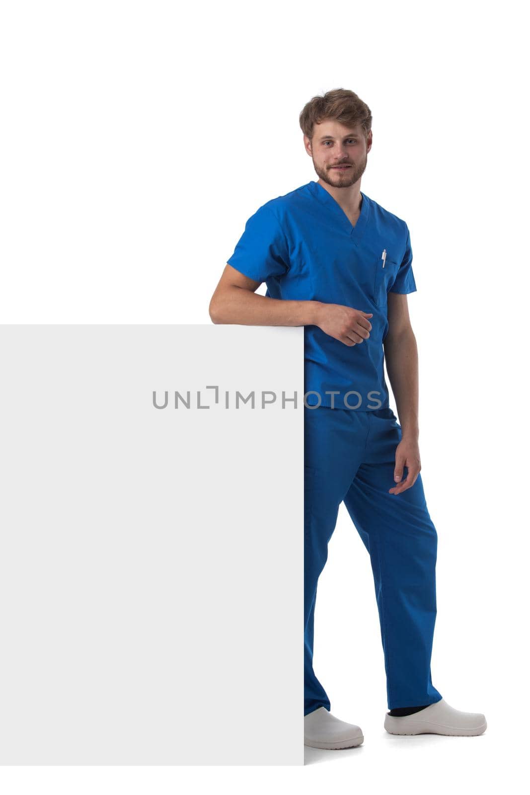 Portrait of a handsome caucasian male doctor nurse with blank banner isolated on white background