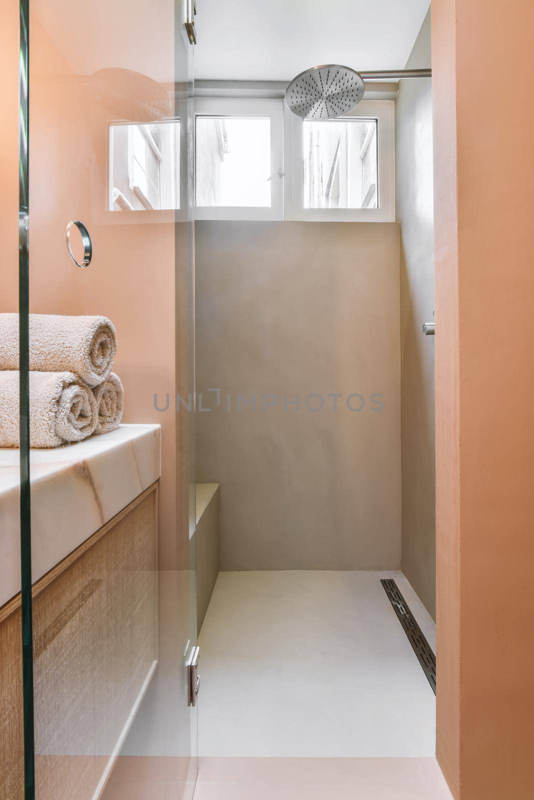 Luxurious bathroom with peach walls and glass shower enclosure