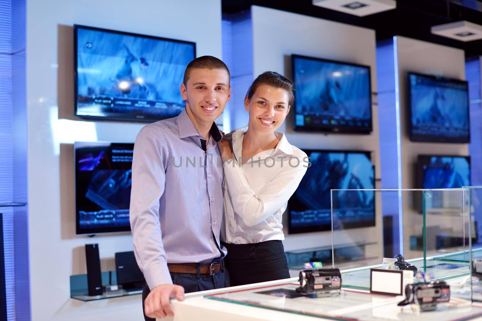 Young couple in consumer electronics store by dotshock