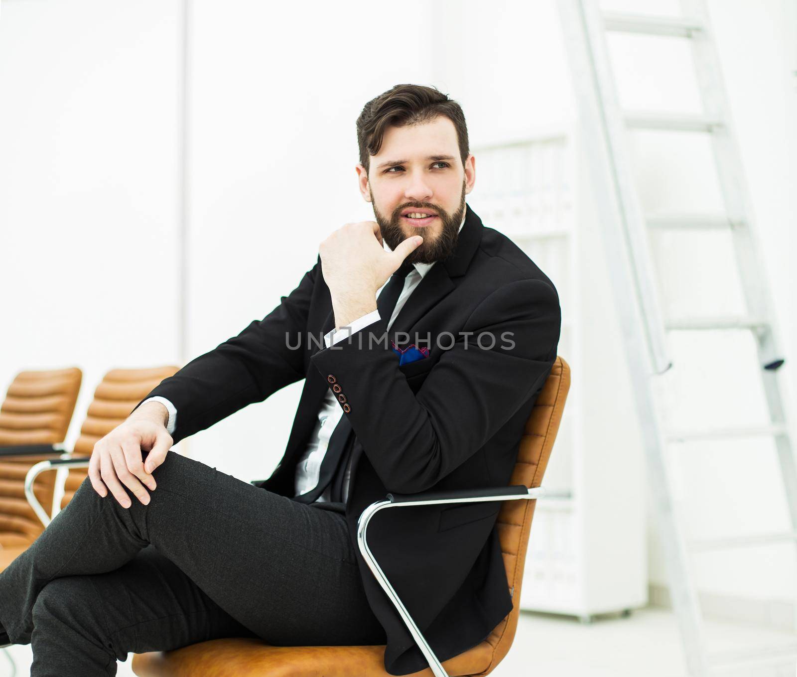 employee of the company sits on a chair near the workplace in the office.the photo has a empty space for your text