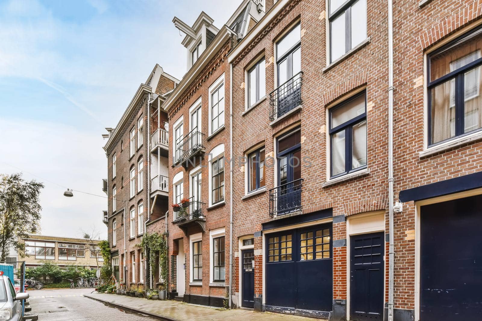 Luxurious two-story brick building with black balconies and doors