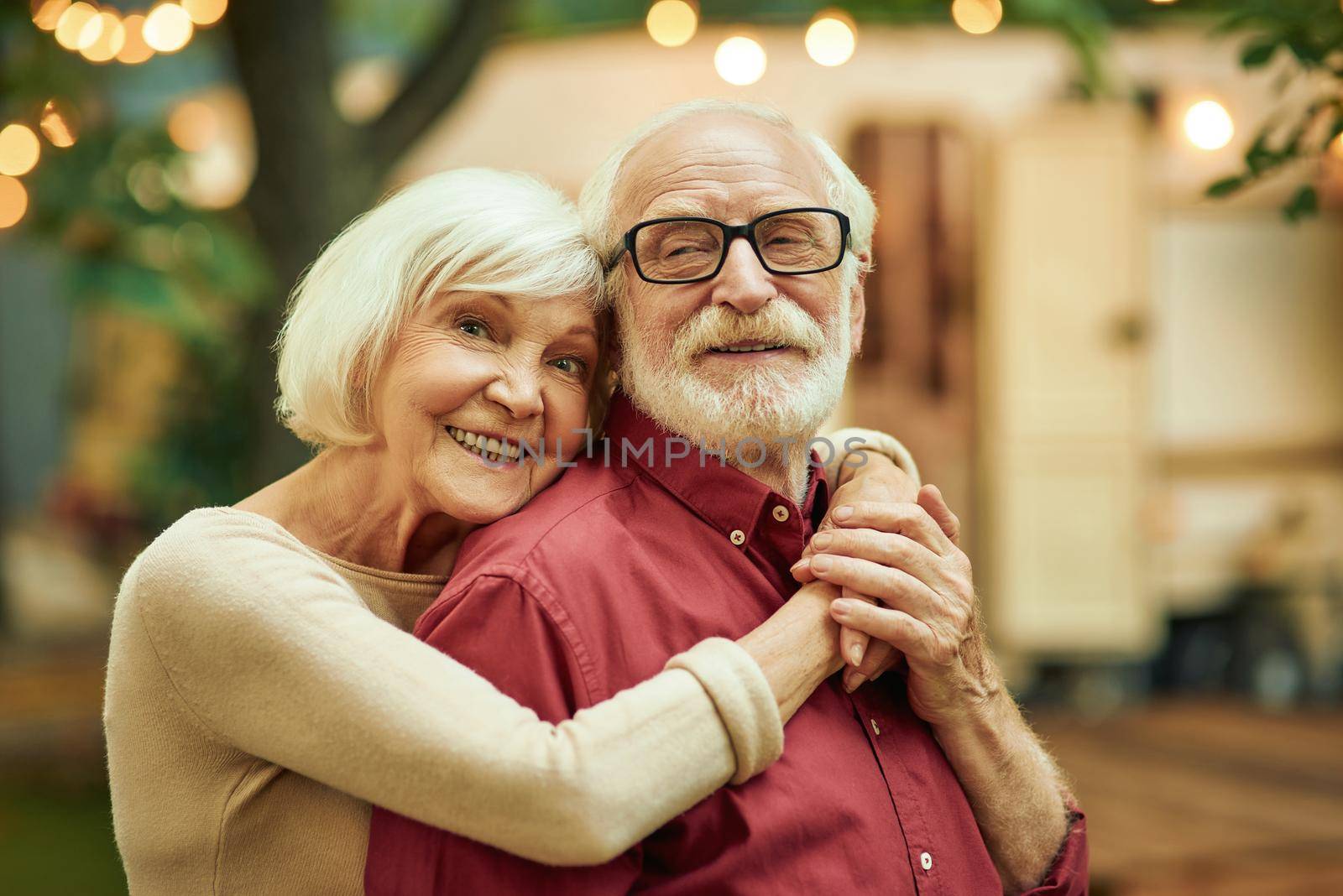 Smiling elderly people standing near their motorhome by friendsstock