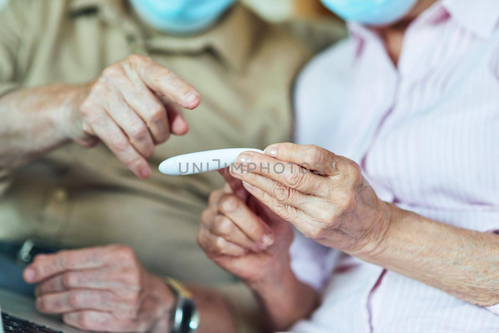 Close up of two pensioners looking at the thermometer by friendsstock