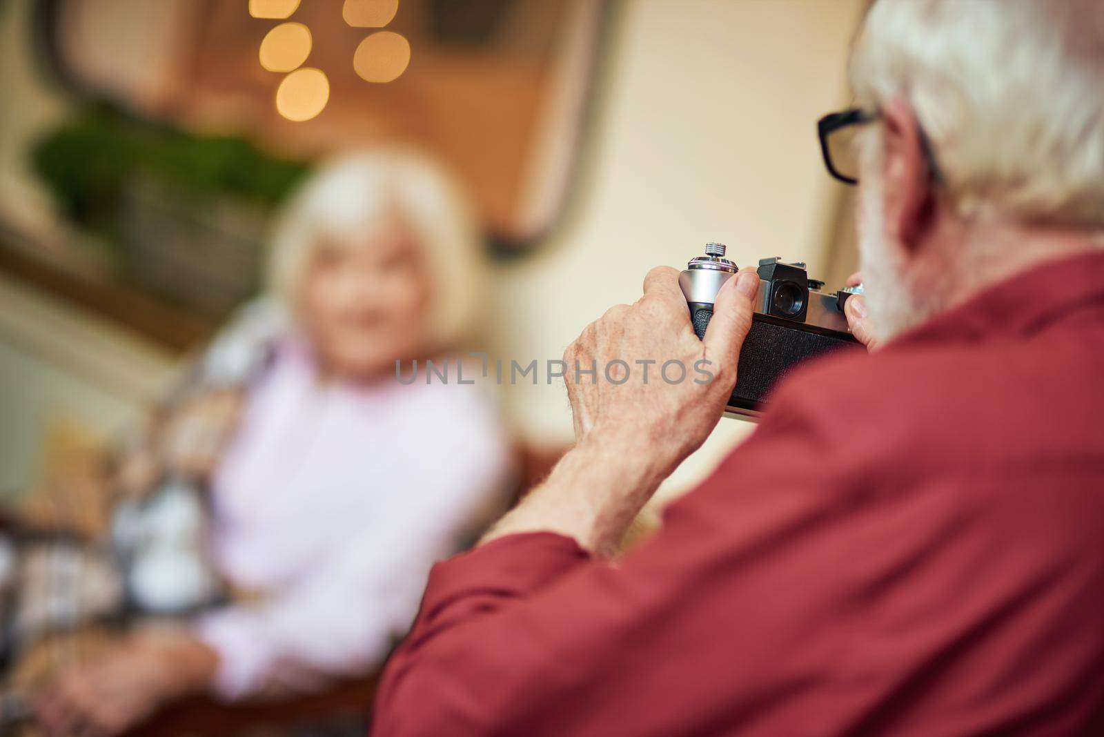 Cropped photo of elderly man making photo of his wife near their camper van. Lifestyle concept