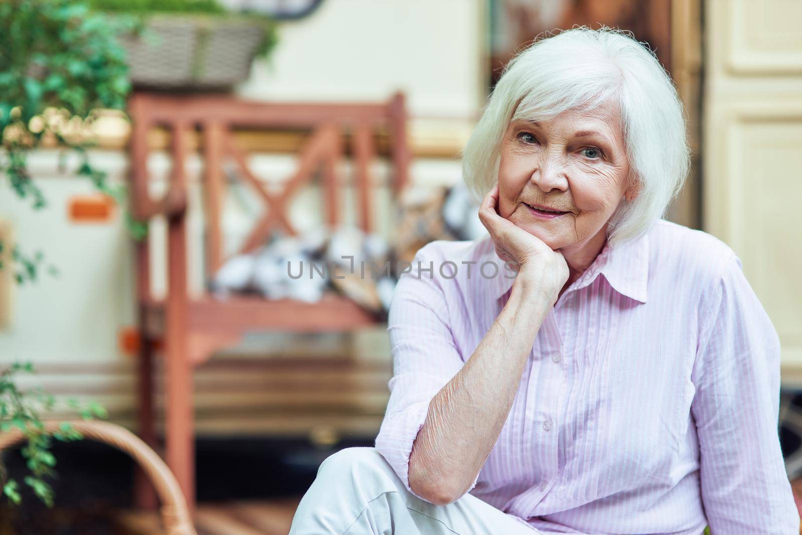 Happy beautiful elderly lady looking at camera outdoors by friendsstock