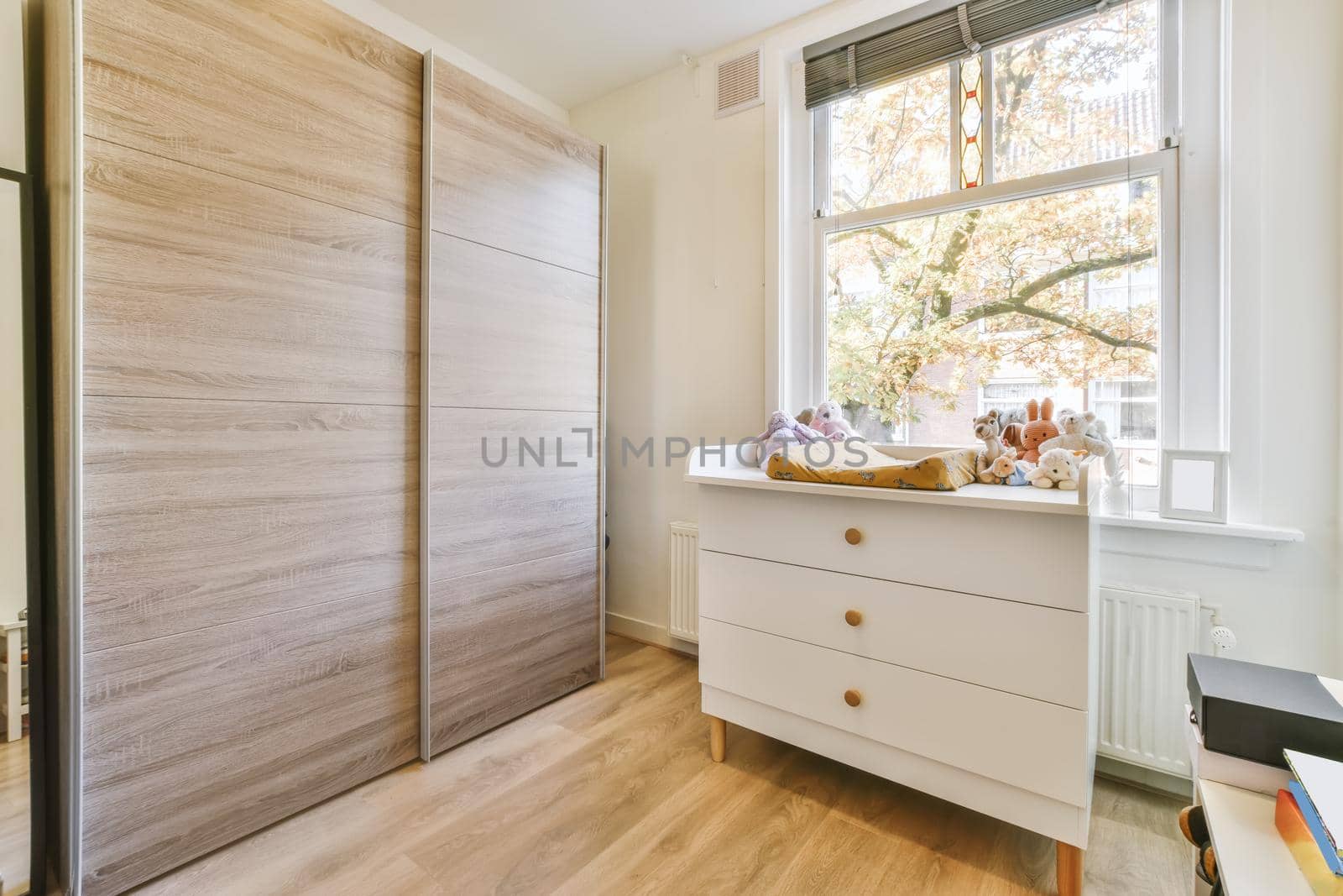 Adorable room with a window overlooking the street and a large wooden wardrobe