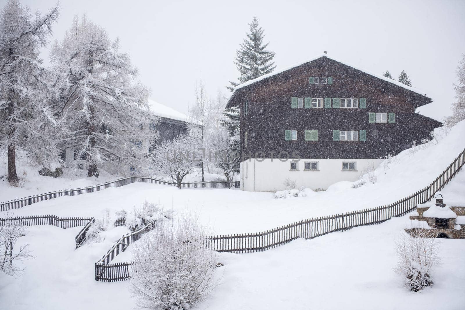 beautiful winter landscape with a mountain house in snowstorm