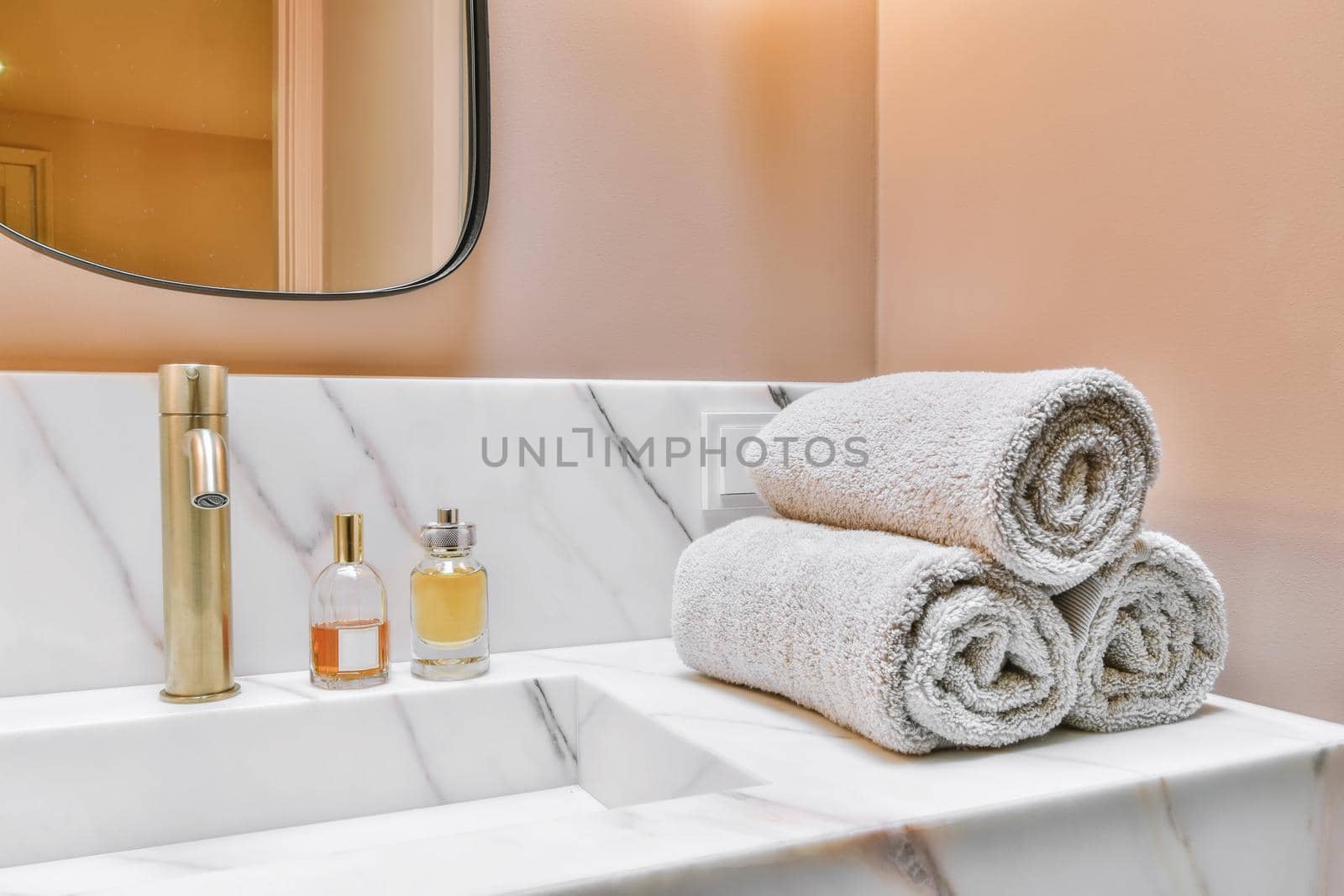 Luxurious washroom with peach walls and marble top and sink