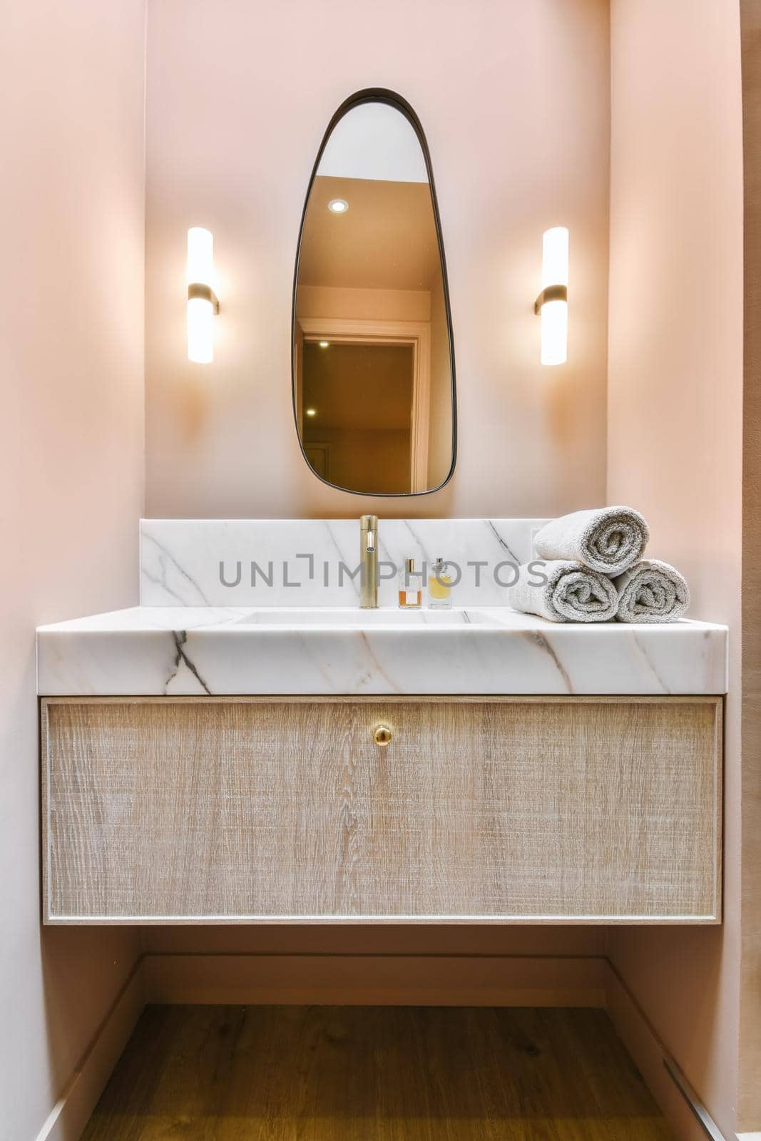 Luxurious washroom with peach walls and marble top and sink