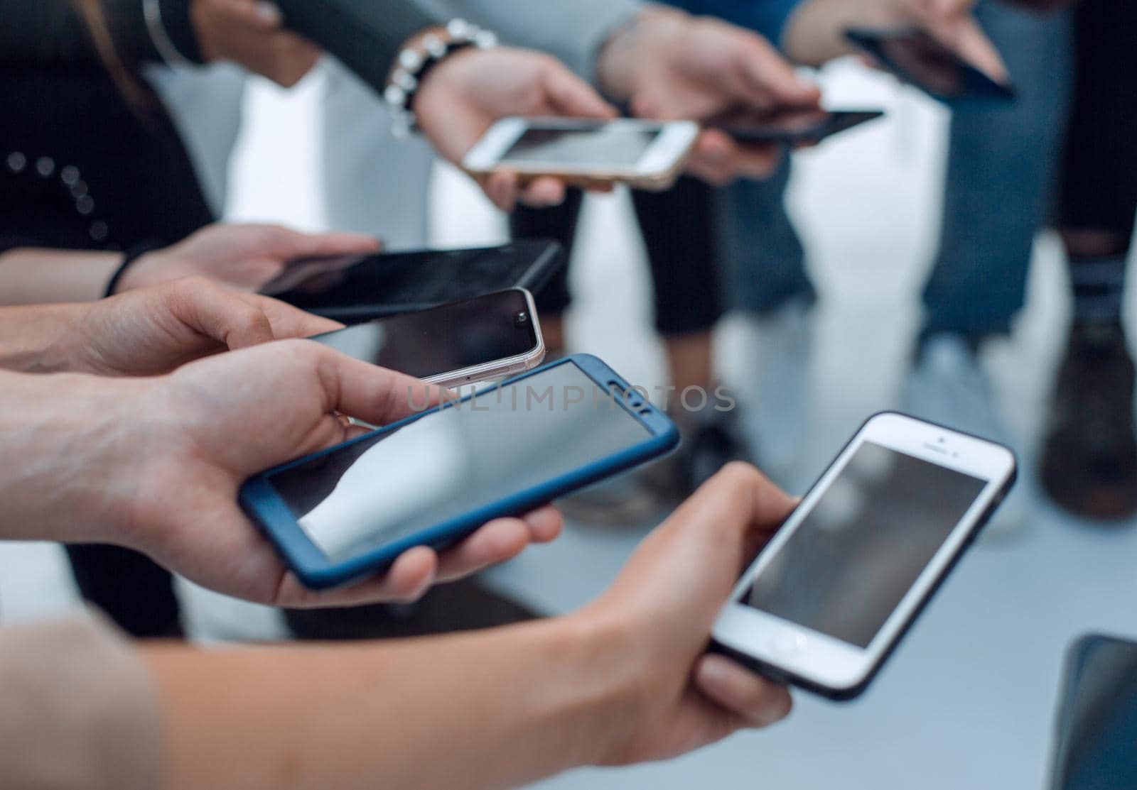 close up. young people with smartphones sitting in a circle. people and technology