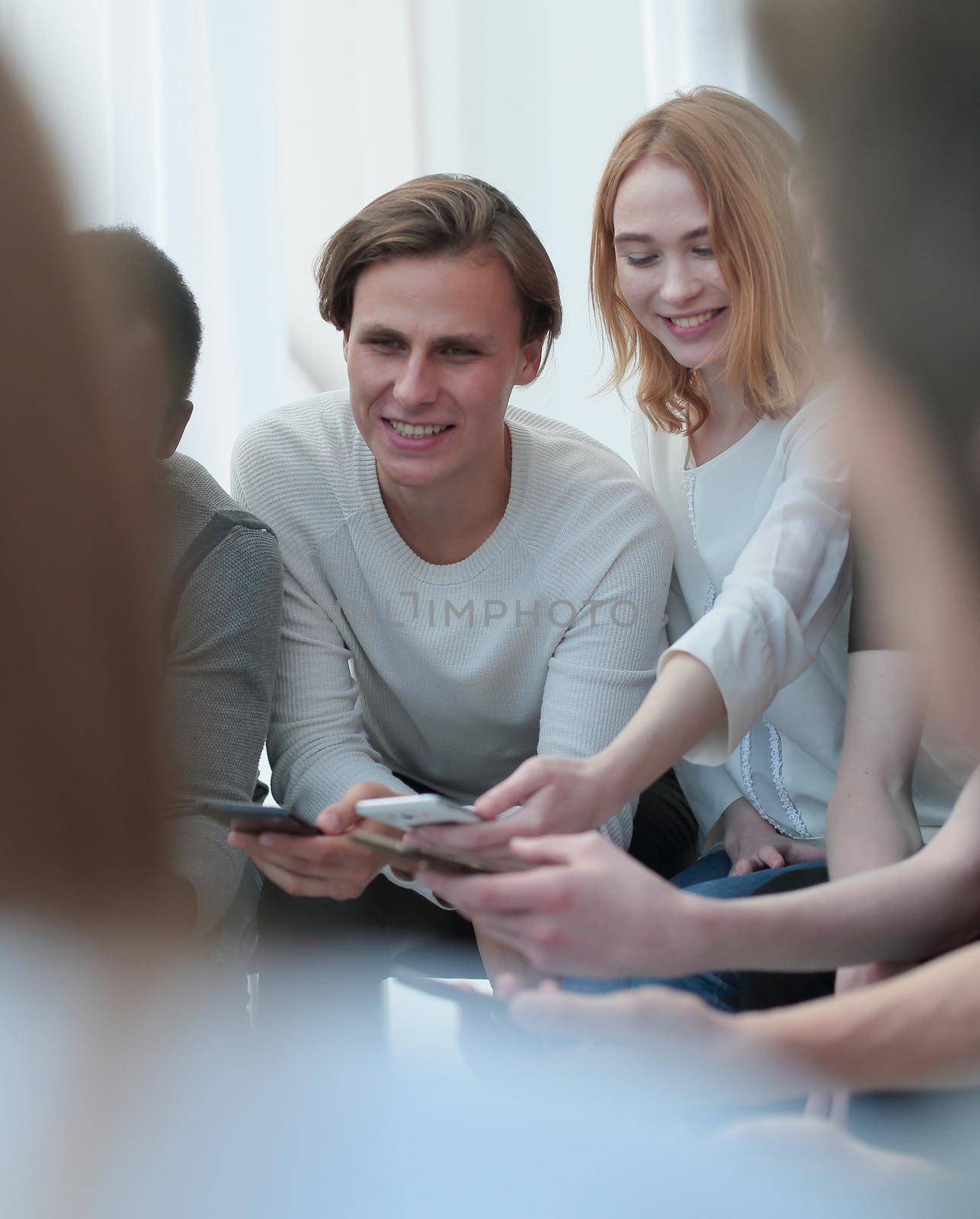 close up. group of young people with smartphones sitting at a table. people and technology