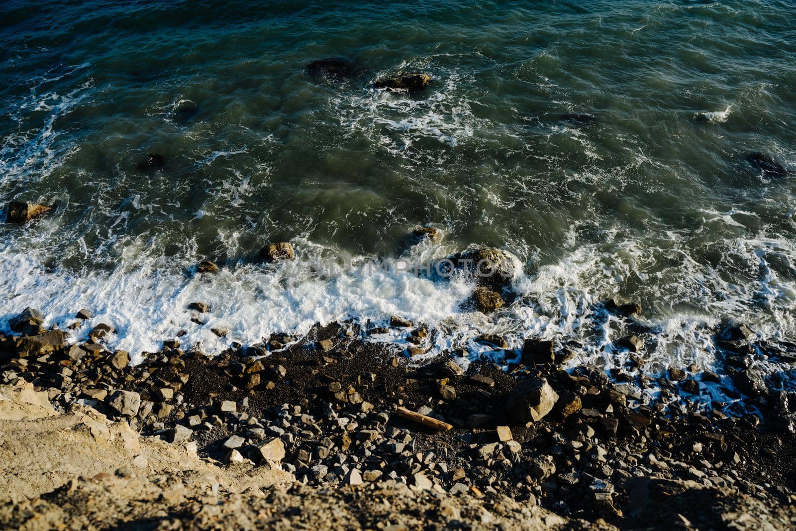 The Black Sea. Top view of the sea waves beating against large rocks. by Rodnova