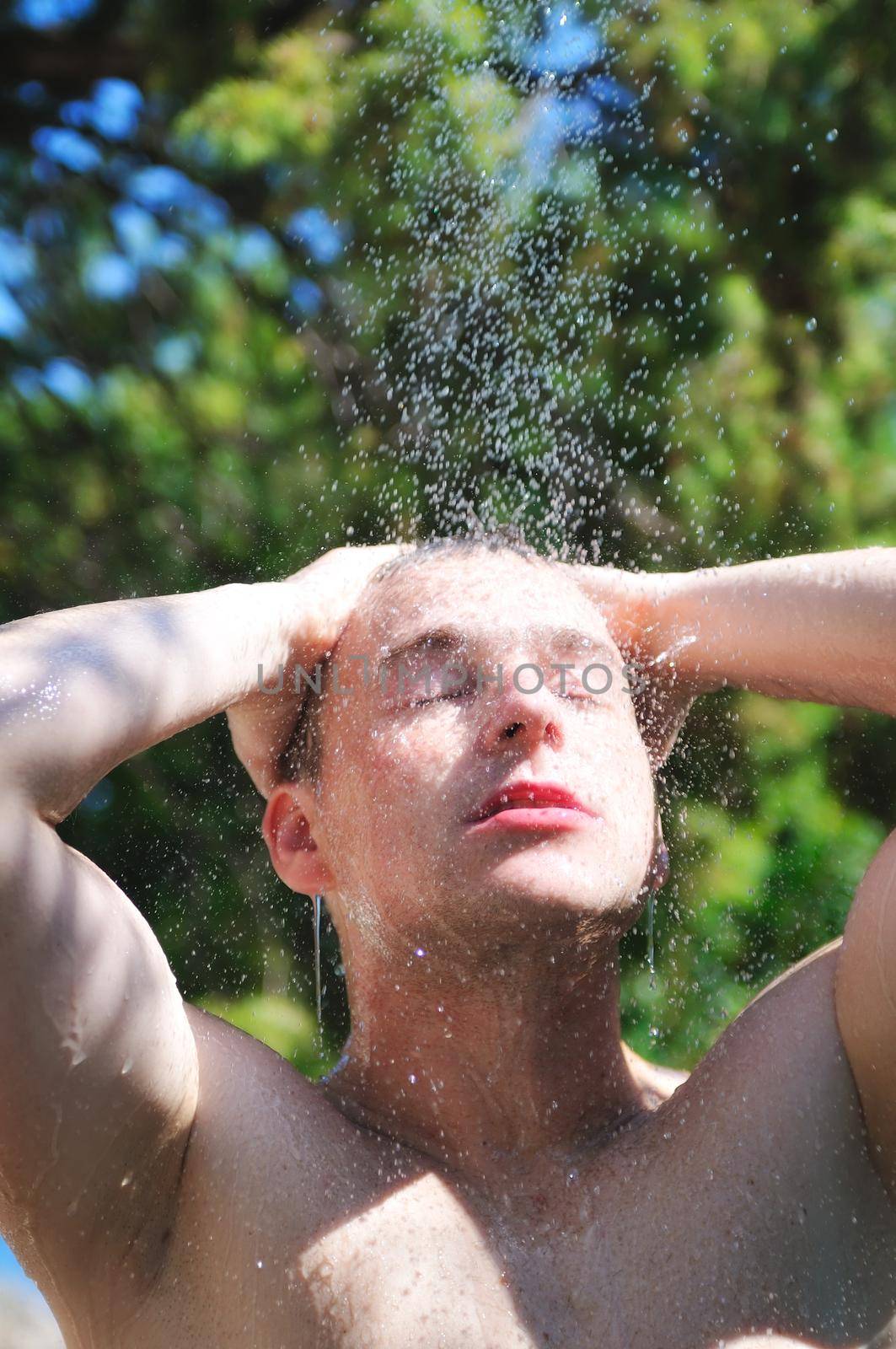 man wash head under shower with falling water