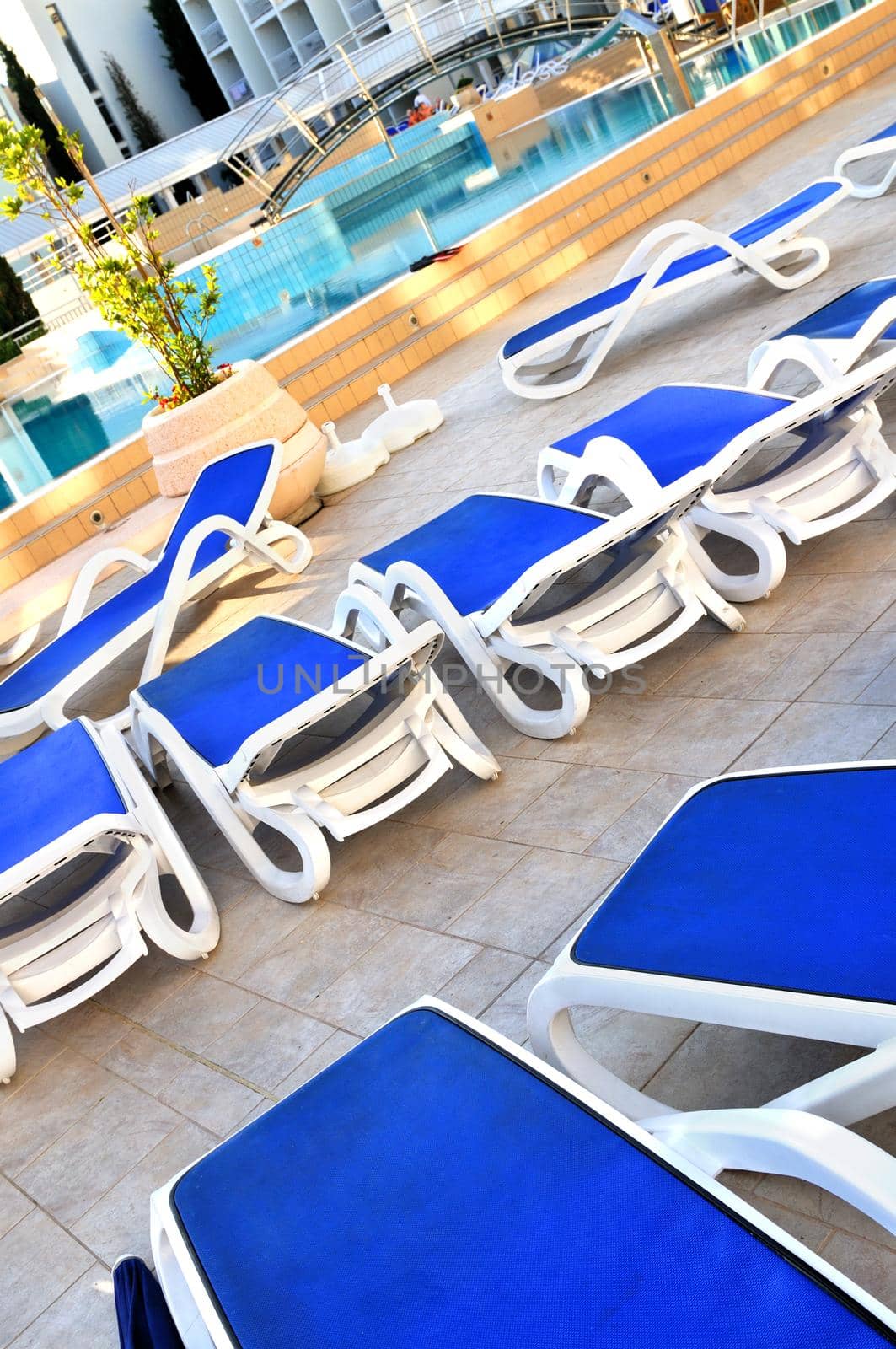 Empty chairs by the pool of luxery hotel