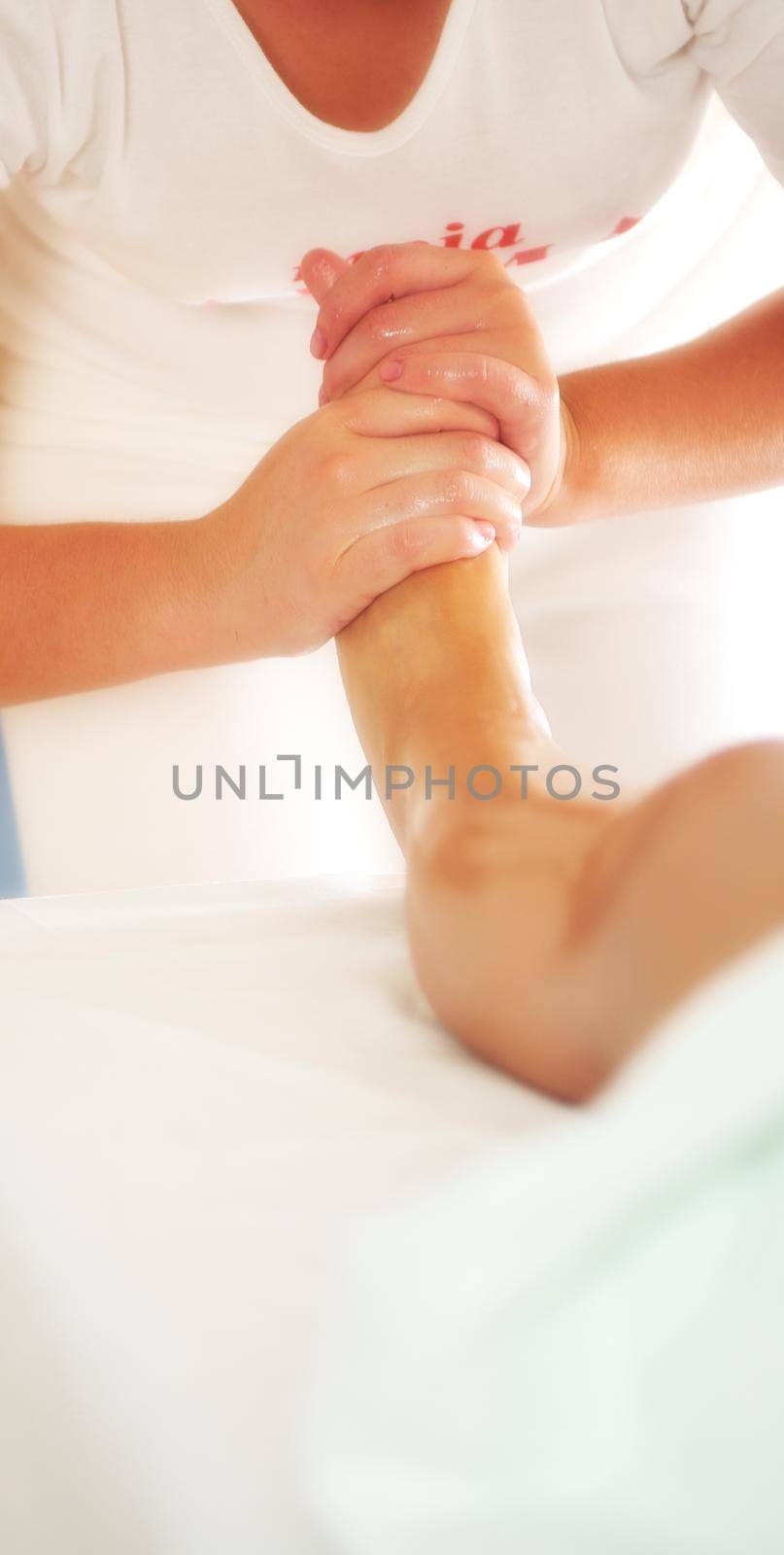 beautiful woman having leg and foot massage at the spa and welln by dotshock