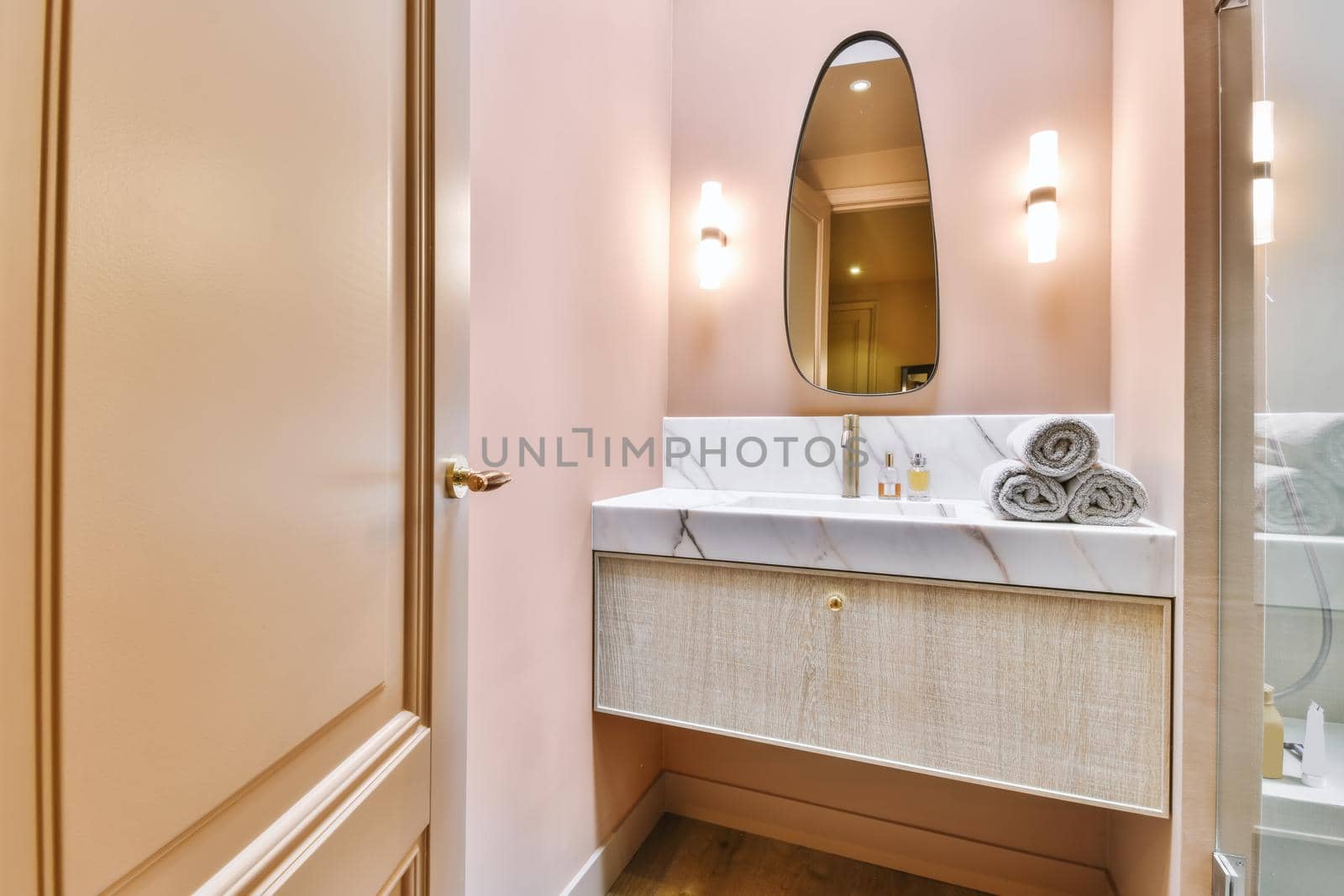 Luxurious washroom with peach walls and marble top and sink