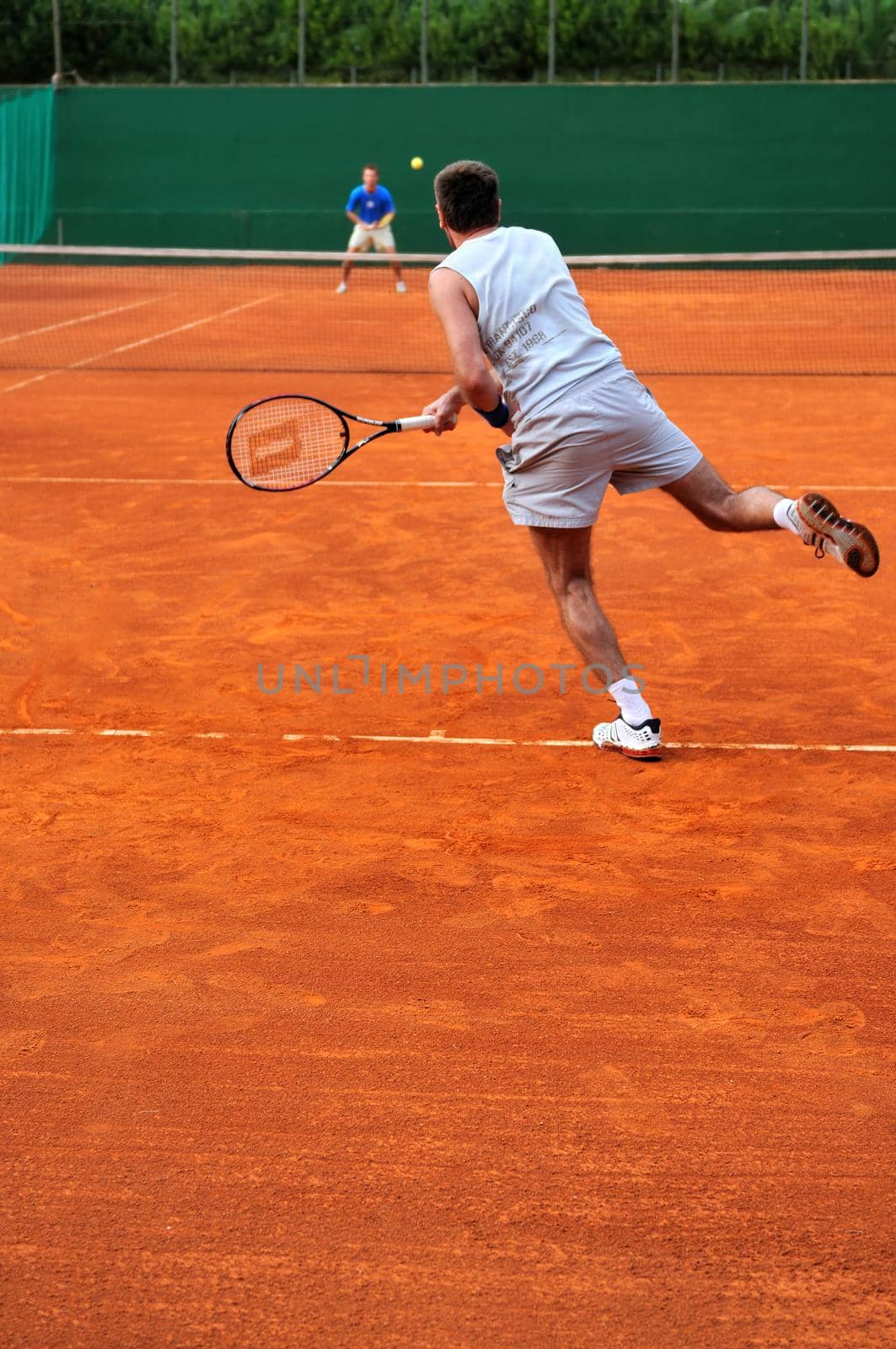 One man play tennis outdoors by dotshock