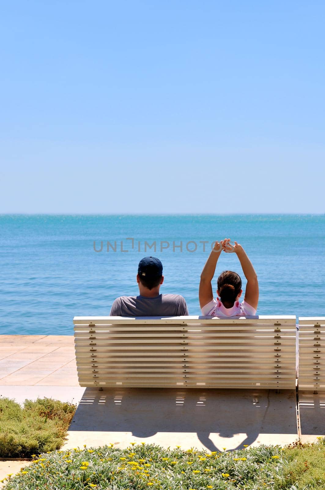 Happy young couple sitting on the beach relaxing