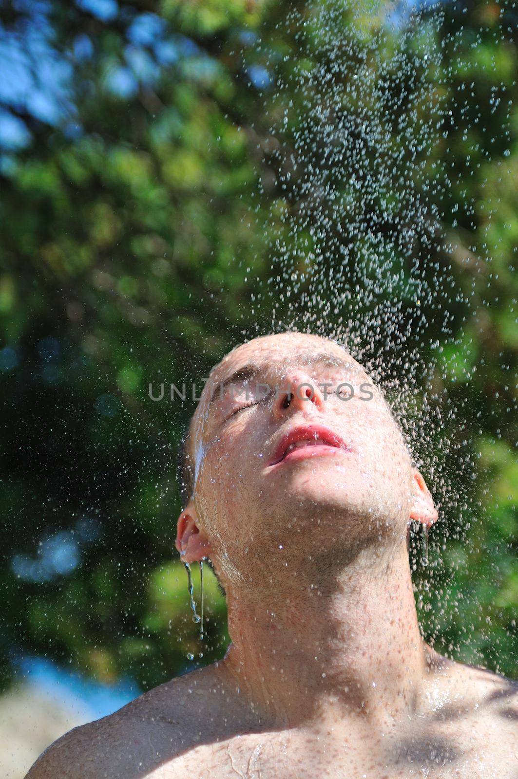 young man relaxing under shower