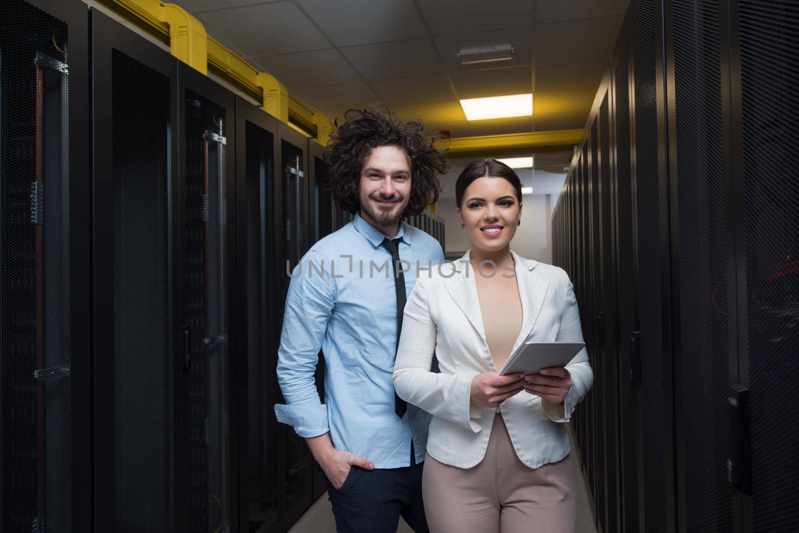 engineer showing working data center server room to female chief by dotshock