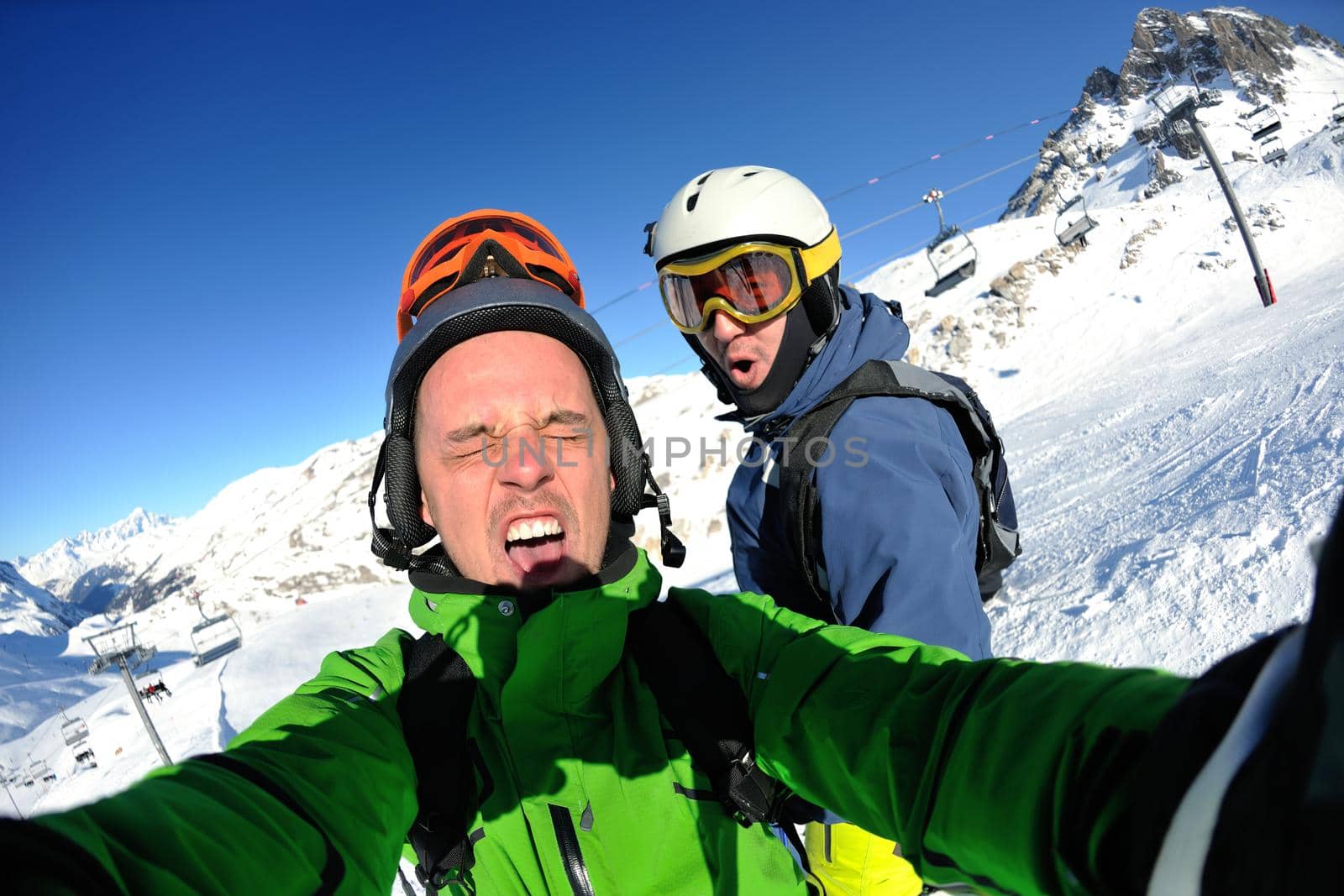 happy people group have fun on ski snow at winter season on mountain with blue sky and fresh air