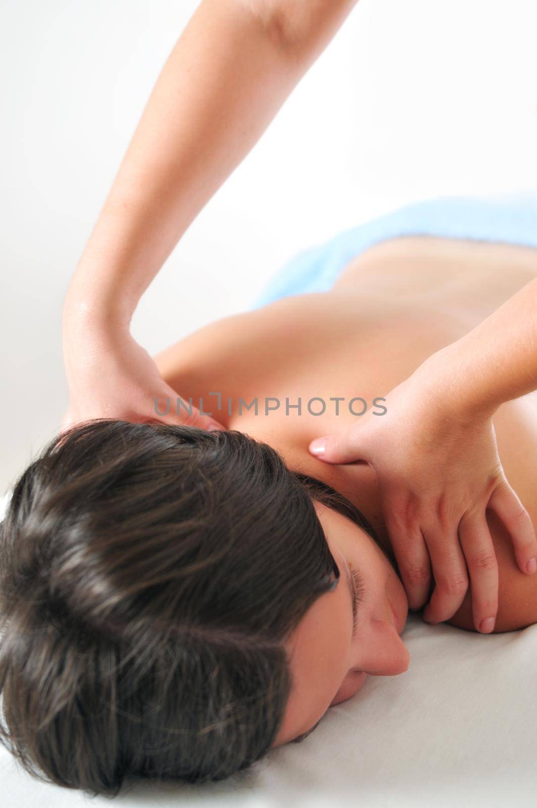 back massage at the spa and wellness center with beautiful brinette woman