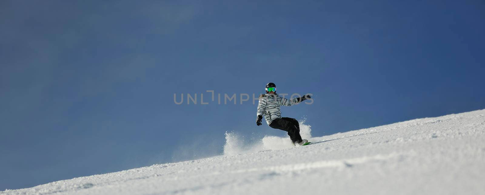 snowboard woman racing downhill slope and freeride on powder snow at winter season and sunny day