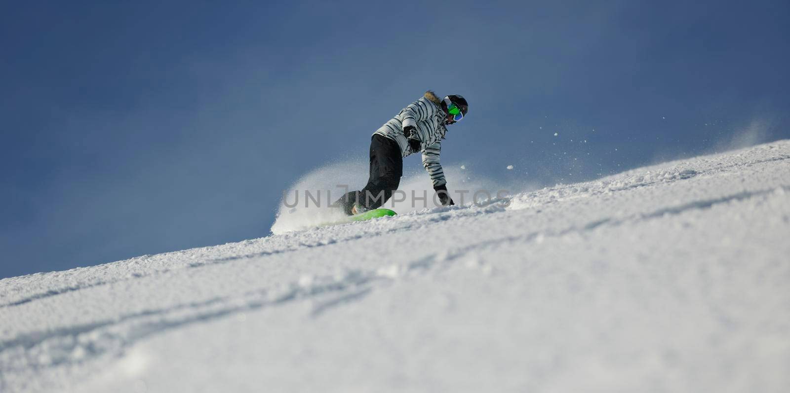 snowboard woman racing downhill slope and freeride on powder snow at winter season and sunny day