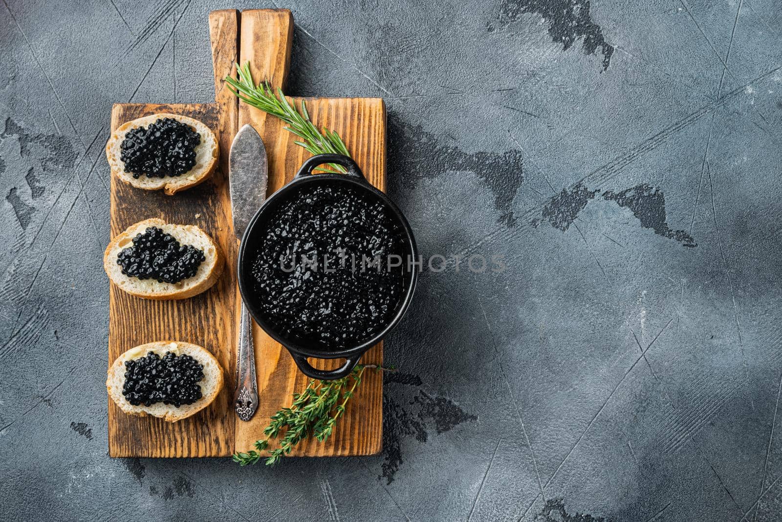 Sandwiches with black caviar and butter, on gray background, top view flat lay with copy space for text