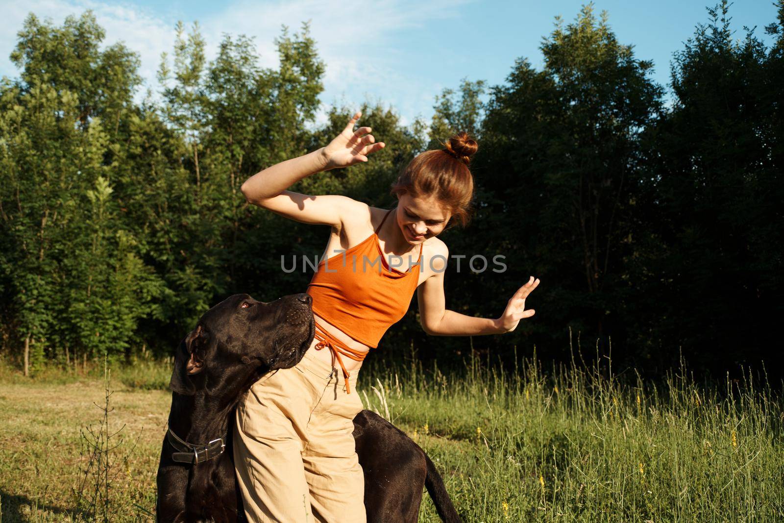 woman outdoors in the field with dog friendship playing. High quality photo