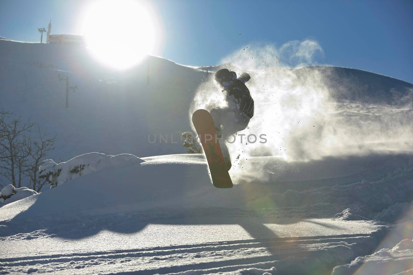 freestyle snowboarder jump and ride free style  at sunny winter day on mountain