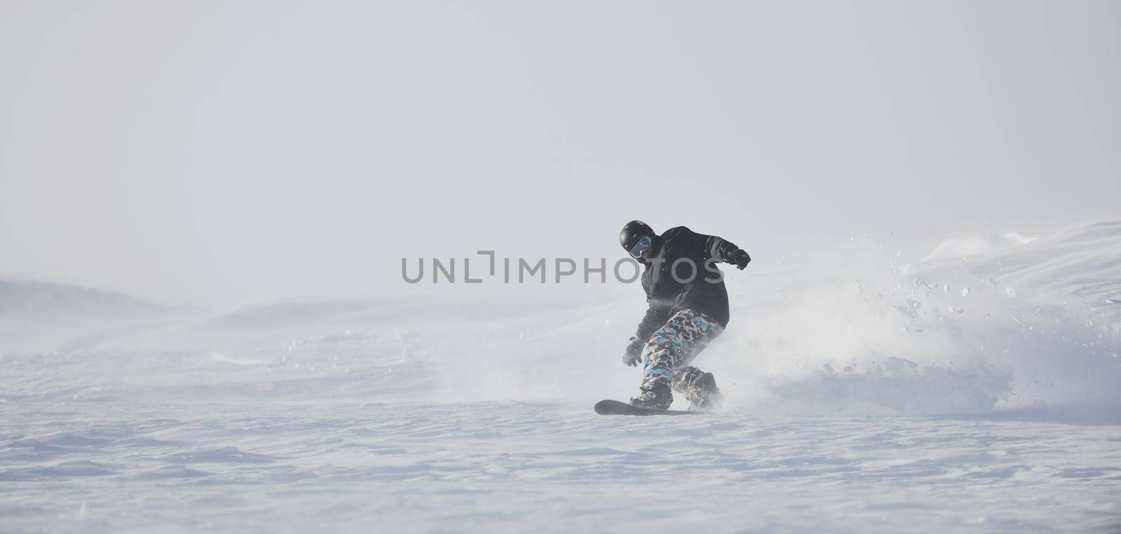 freestyle snowboarder jump and ride free style  at sunny winter day on mountain