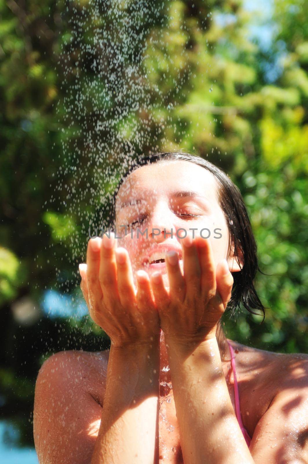 beautiful woman washing and cleaning face under shower