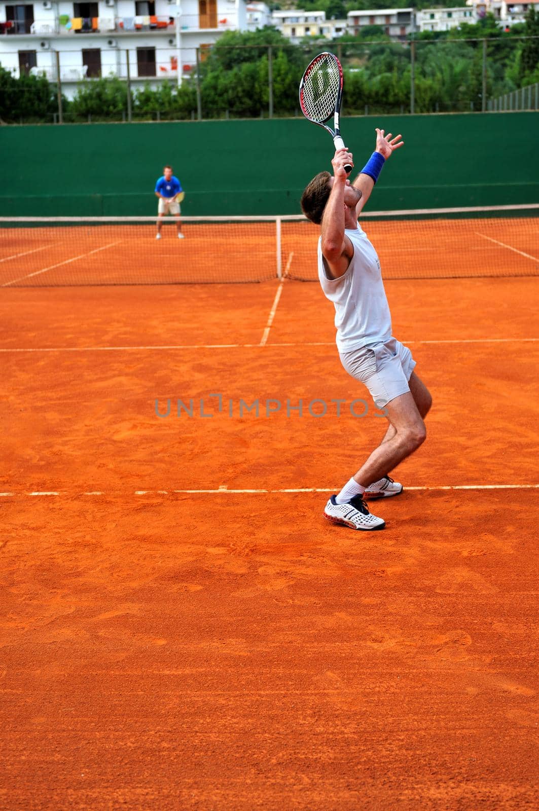 Man plays tennis outdoors by dotshock