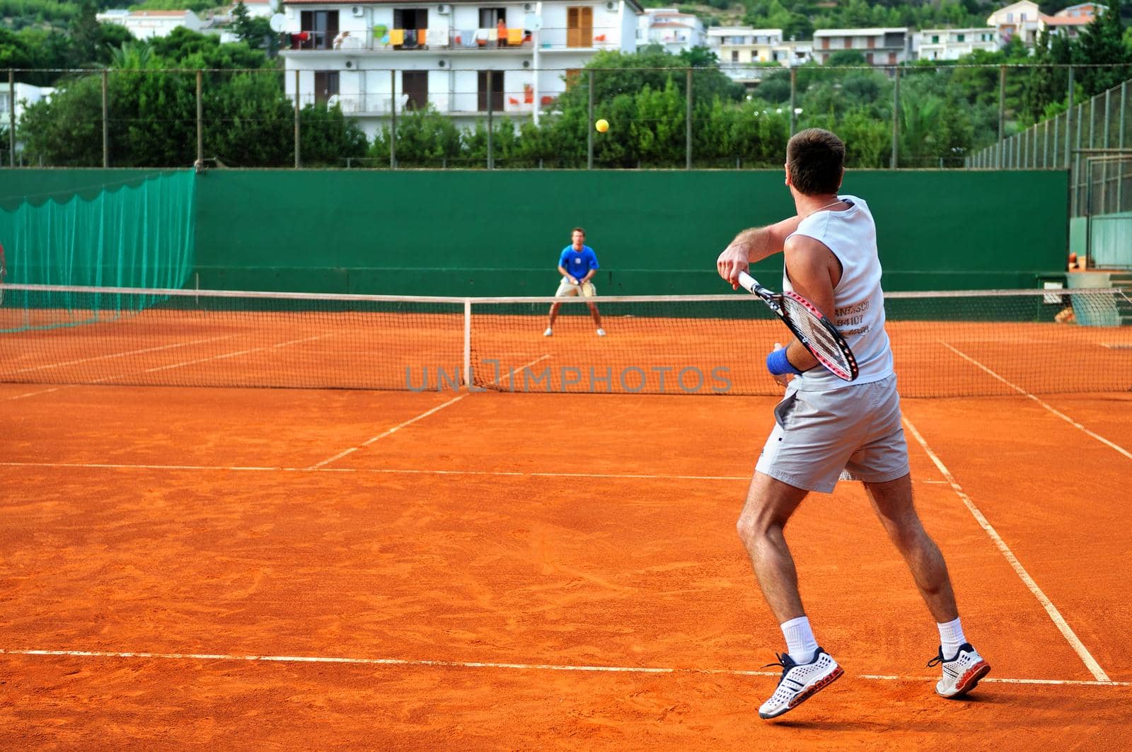 Man plays tennis outdoors by dotshock