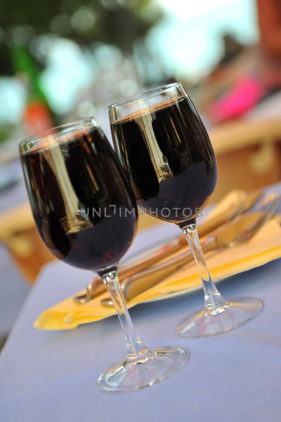 two glasses in outside restaurant with black wine by dotshock